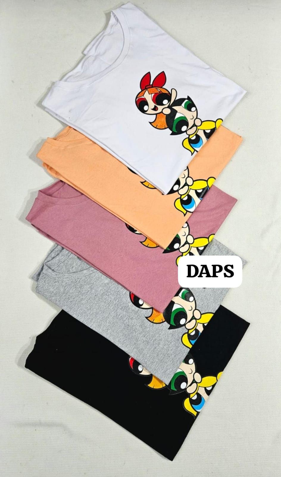 Dos camisetas: una blanca y otra negra, cada una con un diseño de dibujos animados de las Chicas Superpoderosas.