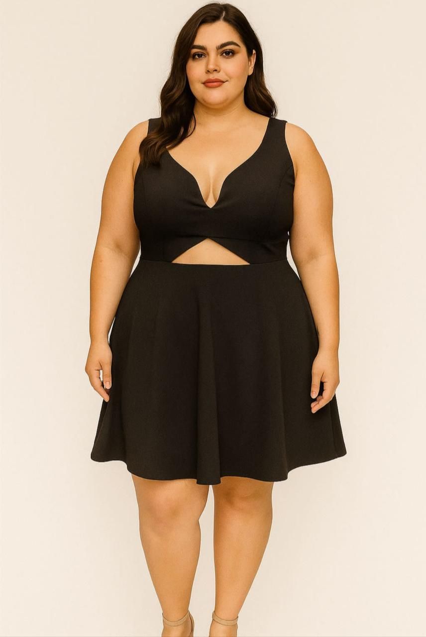 Mujer con un vestido negro con tirantes finos, posando delante de un fondo blanco.