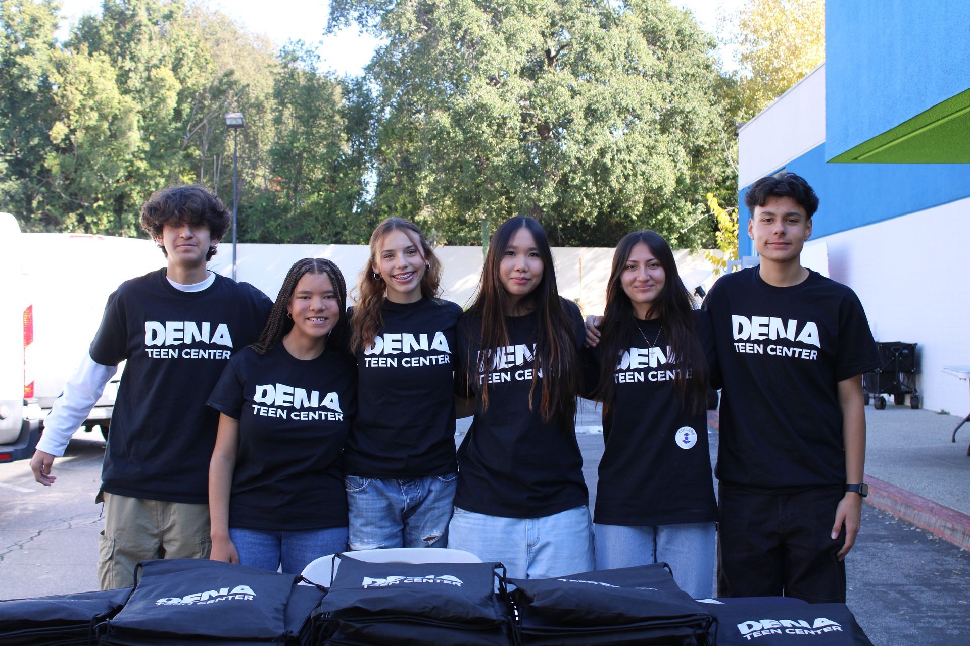 Counselor with boy child posing at a table with pink door behind them.
