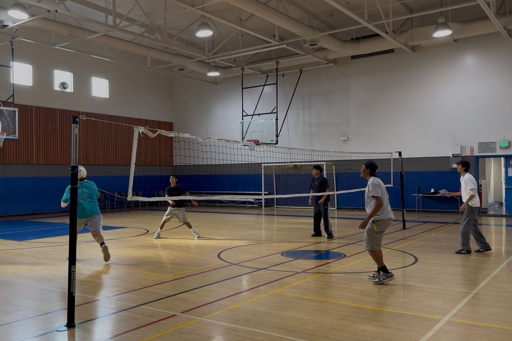 Counselor with boy child posing at a table with pink door behind them.