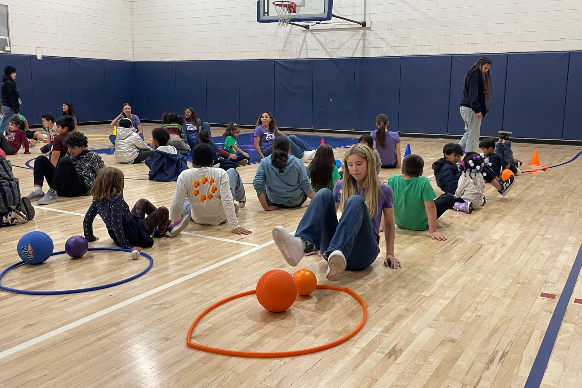 Counselor with boy child posing at a table with pink door behind them.