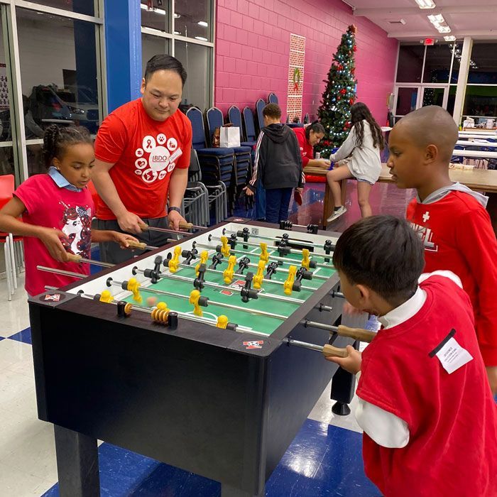 counselor and 3 children playing foosball
