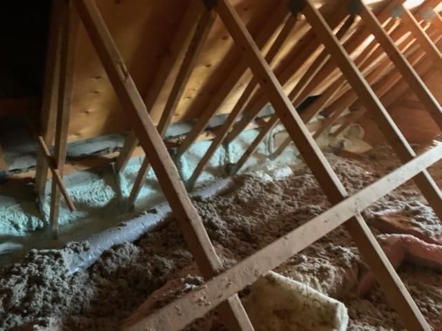 Intérieur mansardé avec chevrons en bois et isolation.