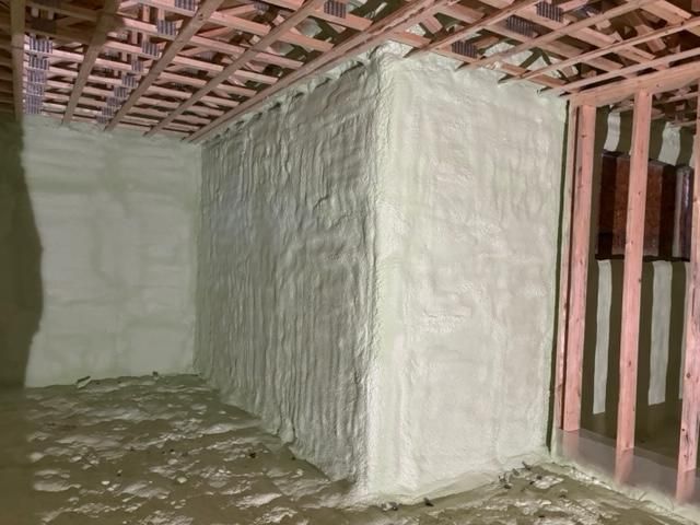 Murs et plafond avec isolation épaisse en mousse pulvérisée dans une pièce en construction.