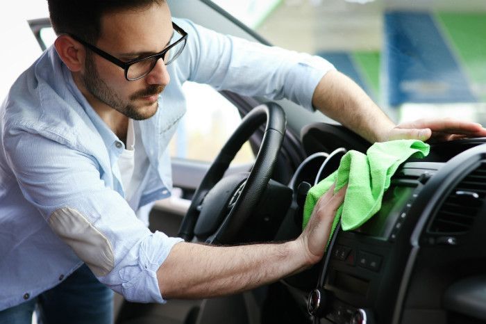 Man cleaning car interior.