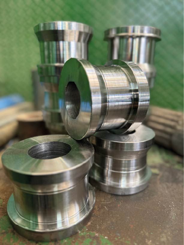 Un montón de cilindros de metal están apilados uno encima del otro sobre una mesa.