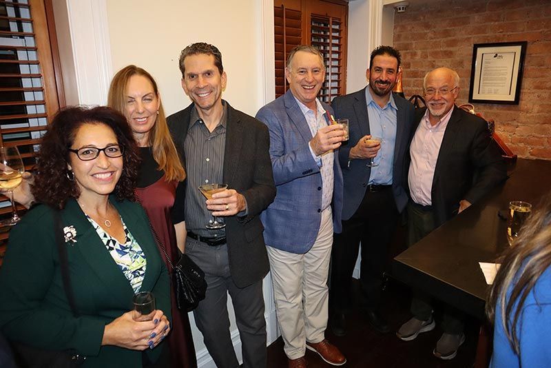 A group of people standing next to each other holding wine glasses.