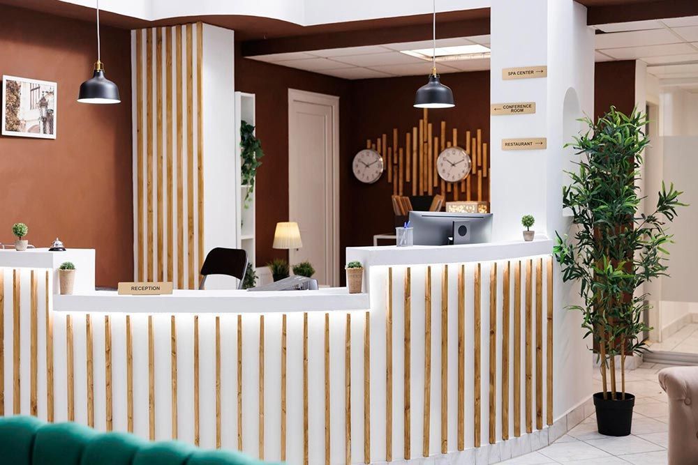 A hotel lobby with a green couch and a white counter.