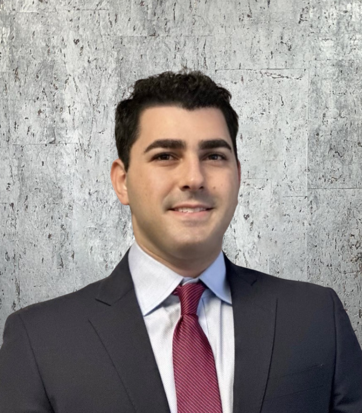 A man in a suit and tie is smiling for the camera.