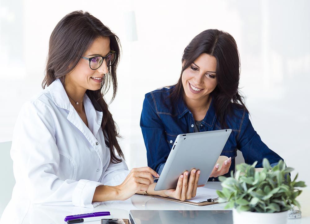 A doctor and a patient are looking at a tablet computer.