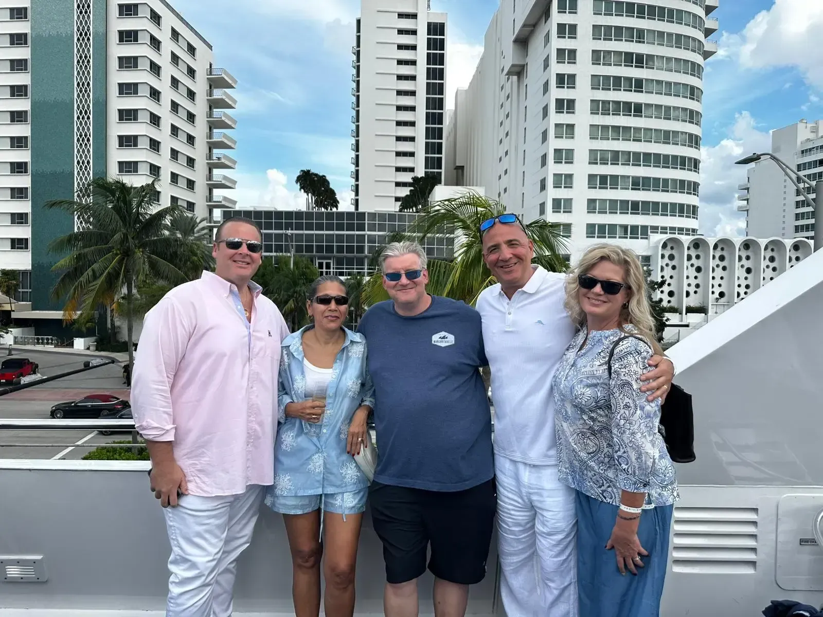 A group of people are posing for a picture in front of tall buildings.