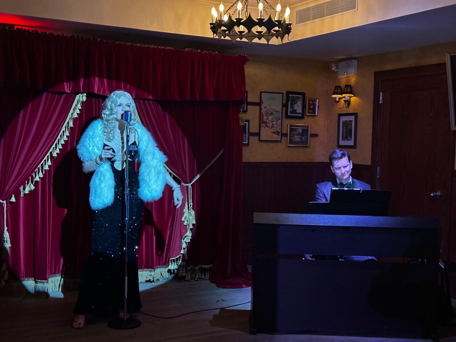 A woman singing into a microphone while a man plays a keyboard