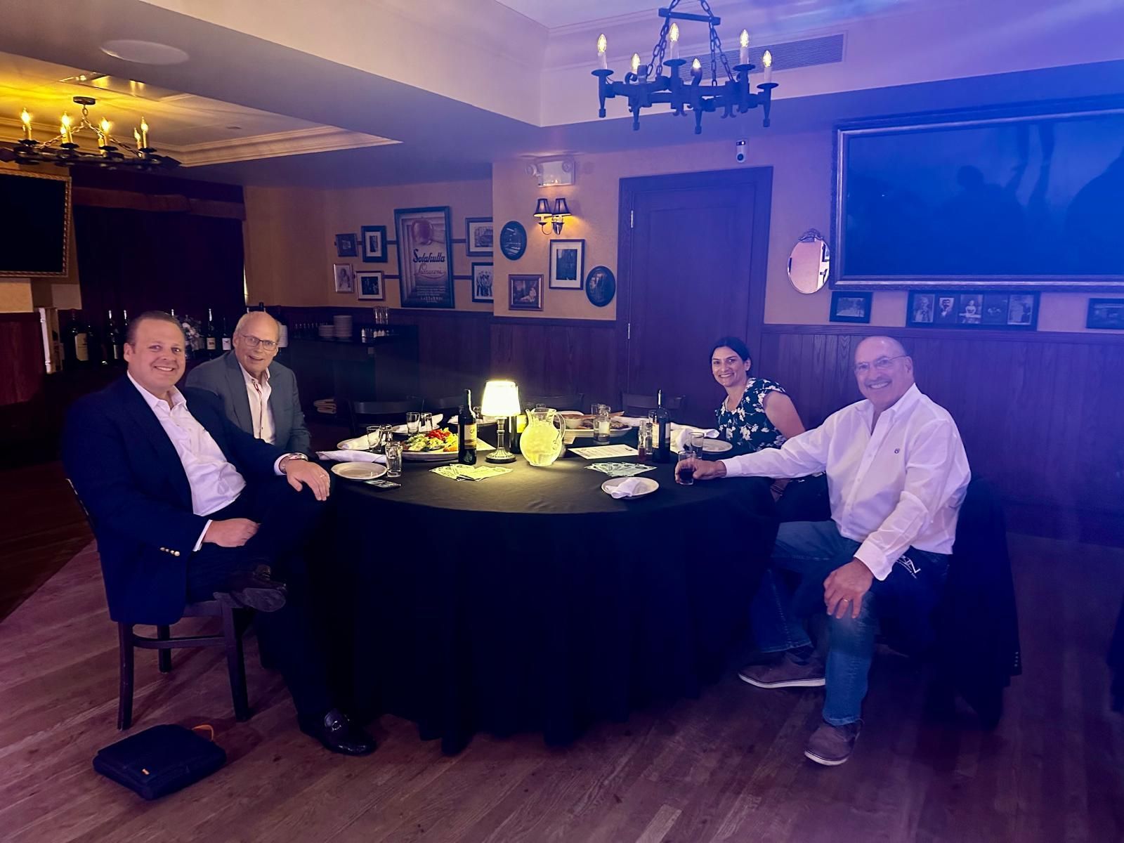 A group of people are sitting around a table in a restaurant.