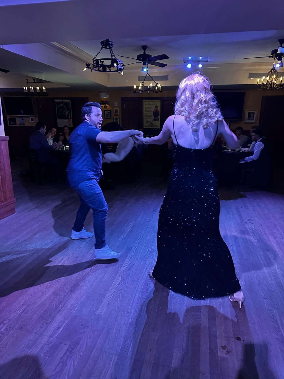 A man and a woman are dancing in a dark room.