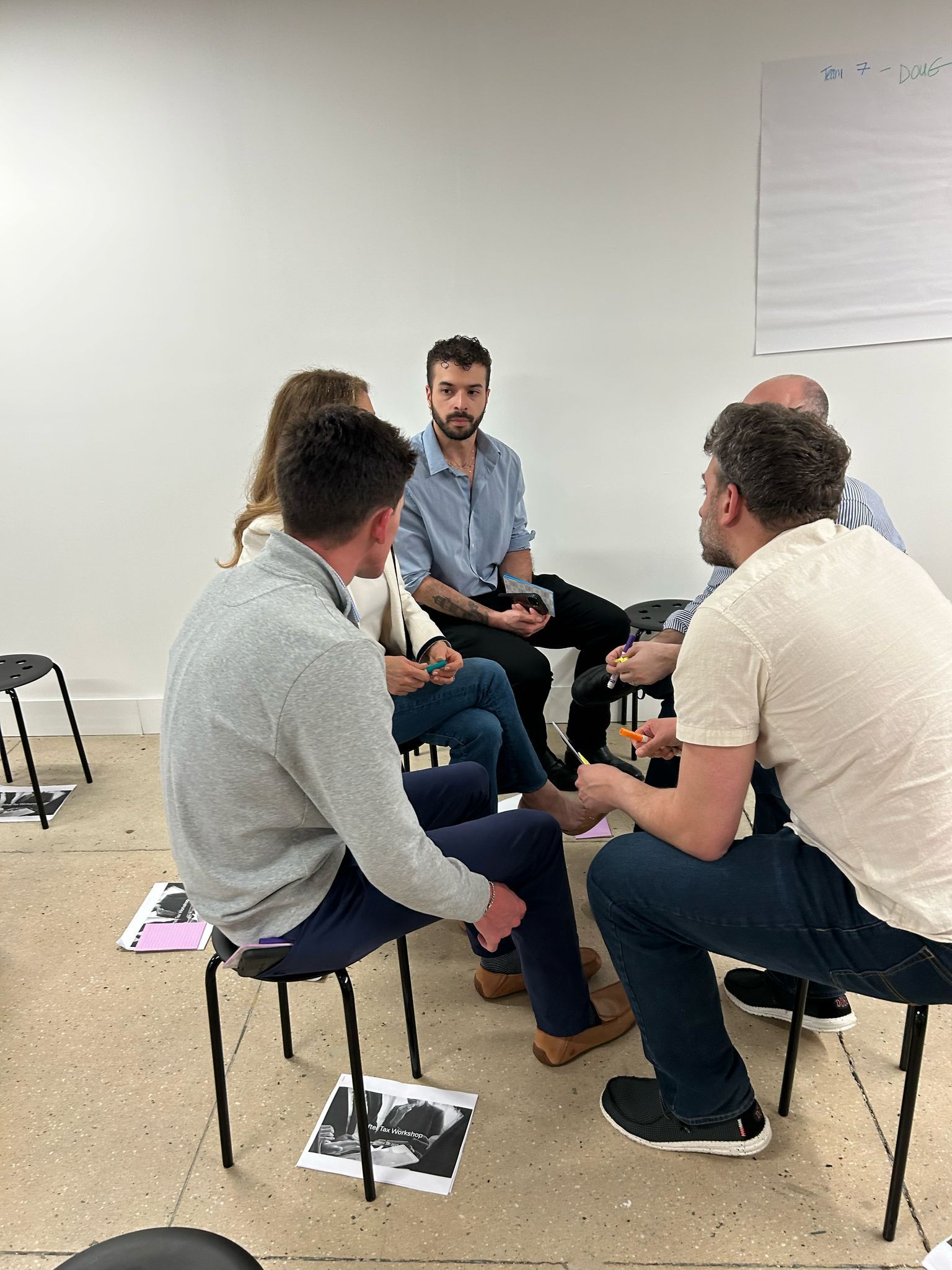A group of people are sitting in a circle talking to each other.