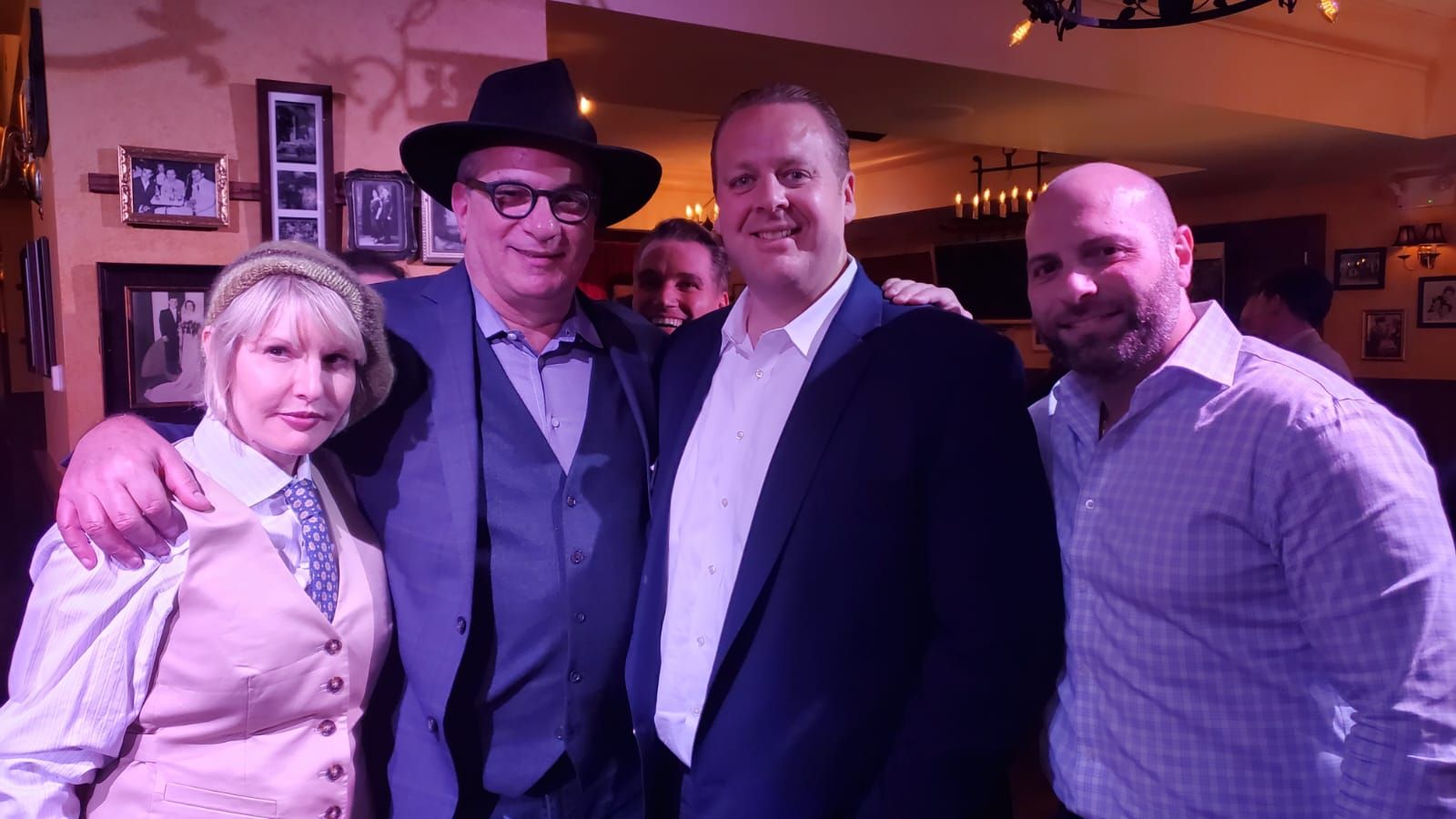 A group of people are posing for a picture in a dark room.