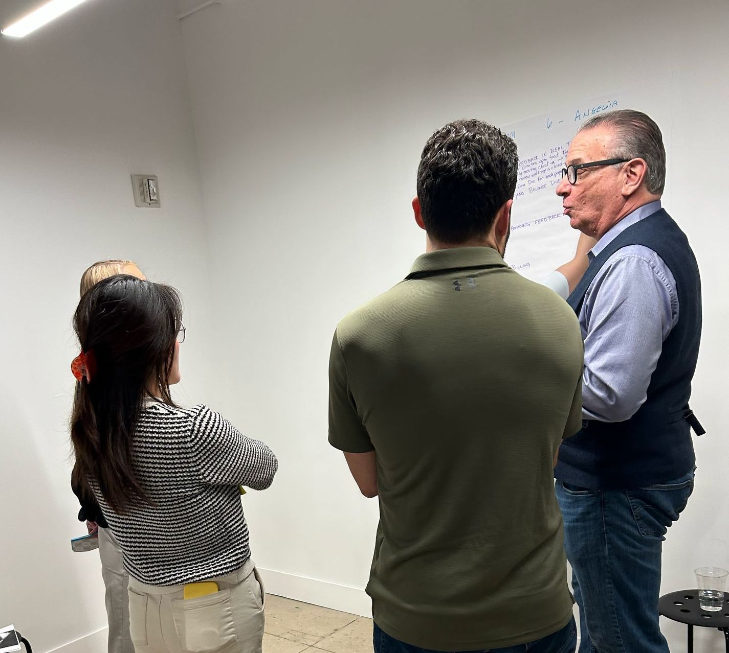 A group of people standing in front of a white board