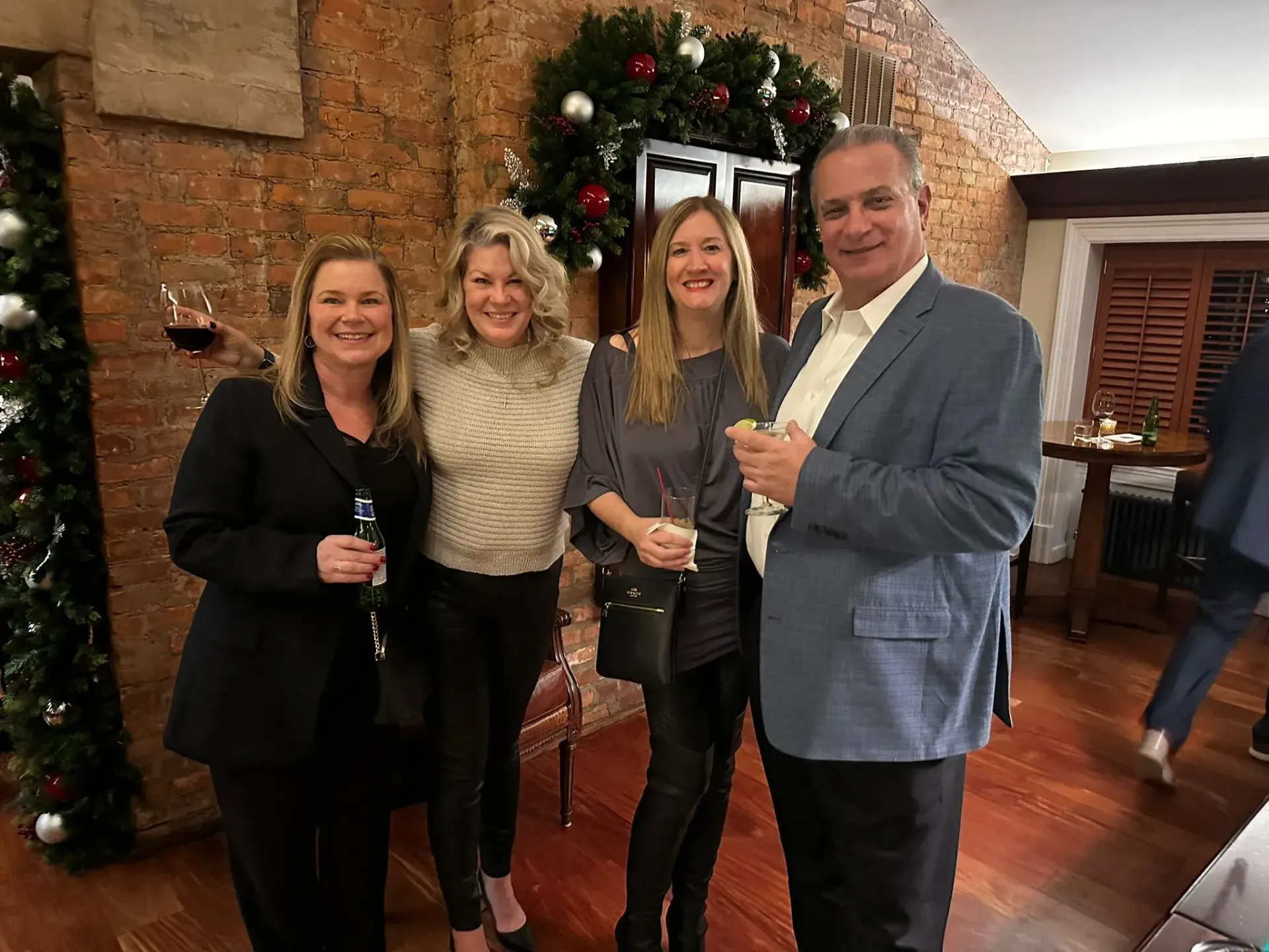 A group of people are posing for a picture in a room with a christmas tree in the background.