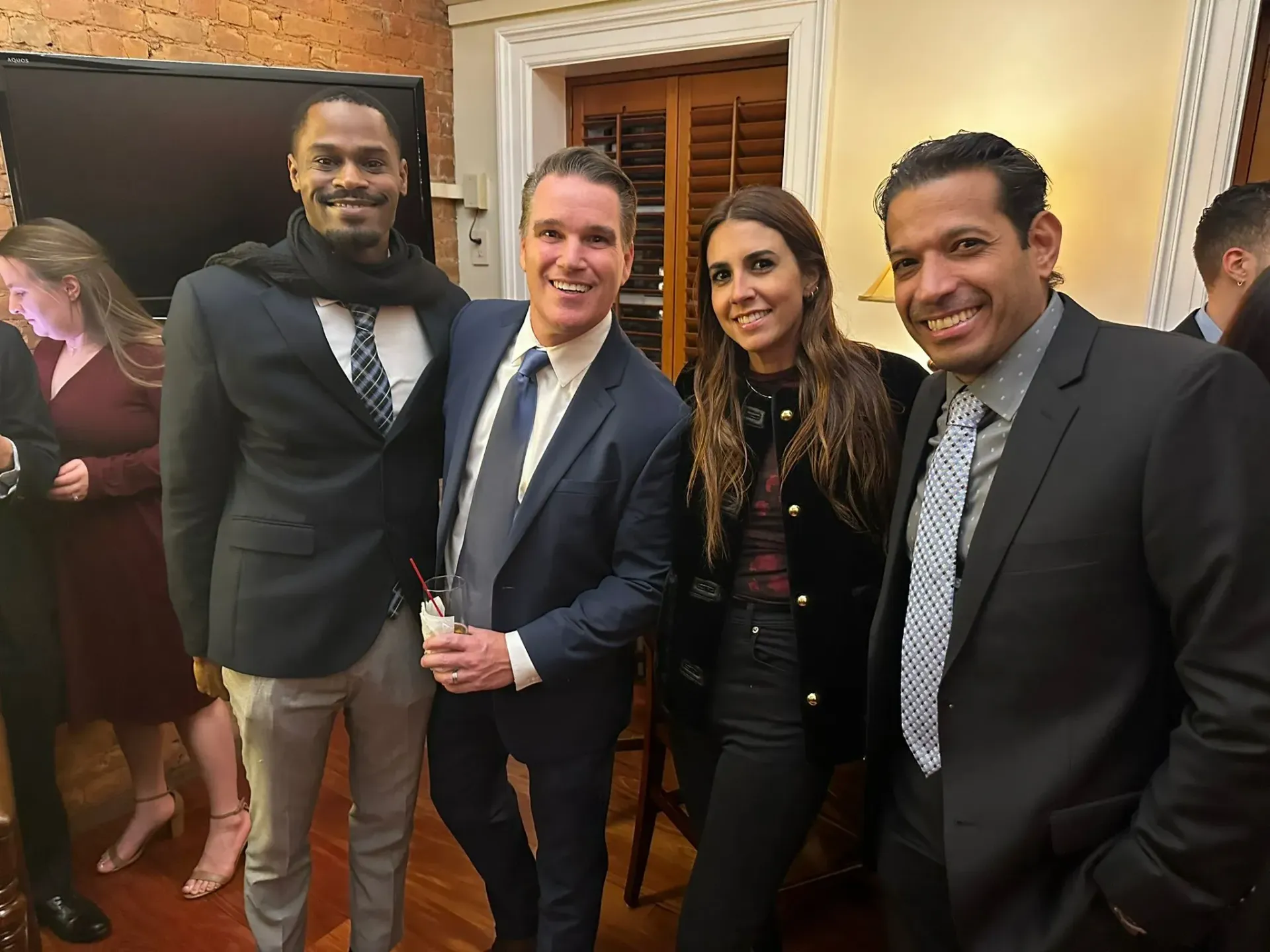 A group of people in suits and ties are posing for a picture.