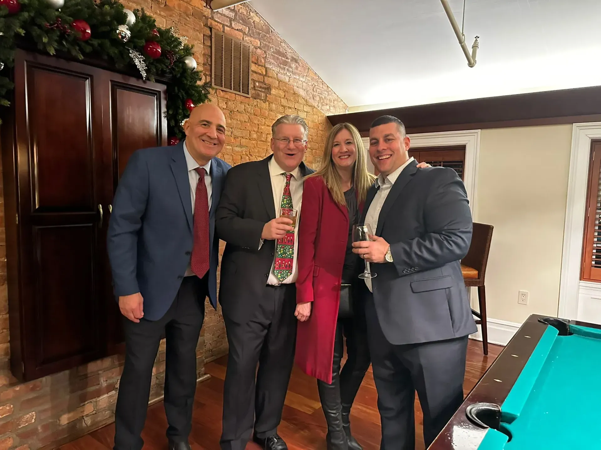 A group of people are posing for a picture in front of a pool table.