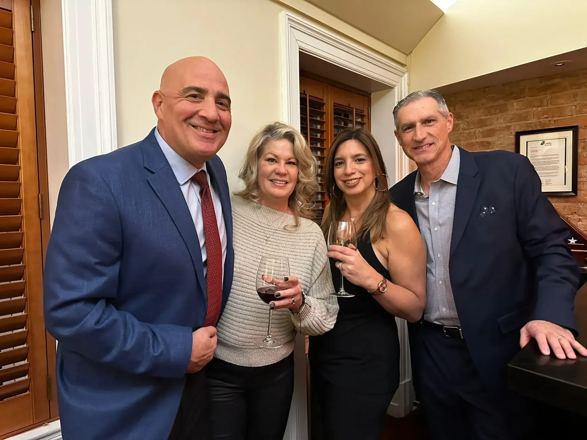 A group of people standing next to each other holding wine glasses.