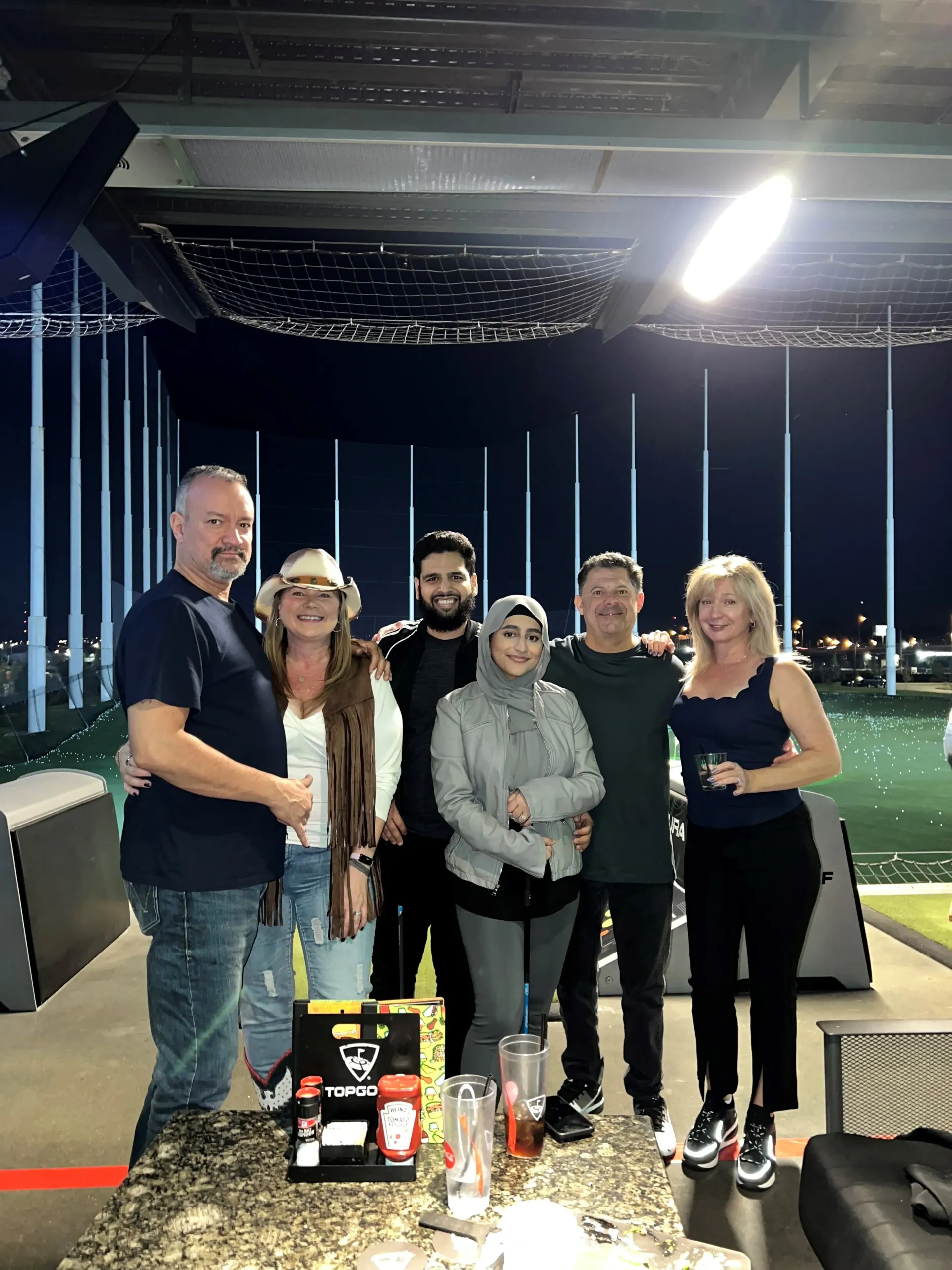 A group of people are posing for a picture at a golf course.