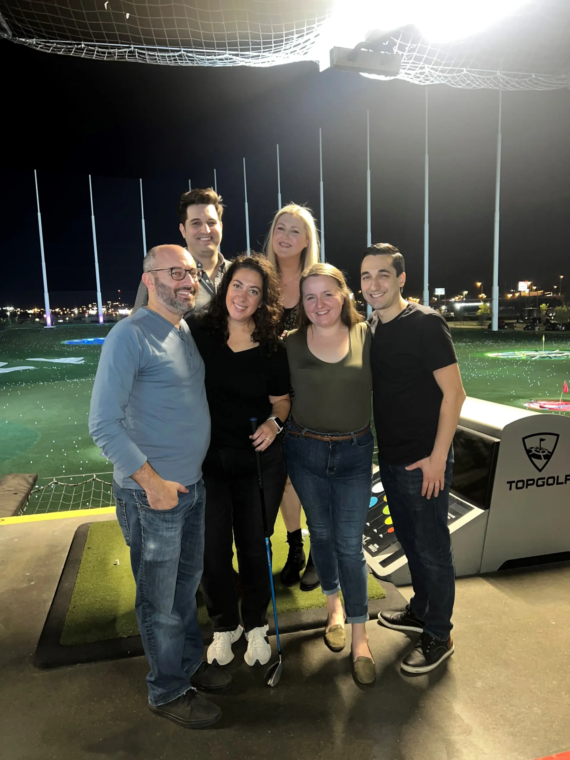 A group of people are posing for a picture on a golf course.