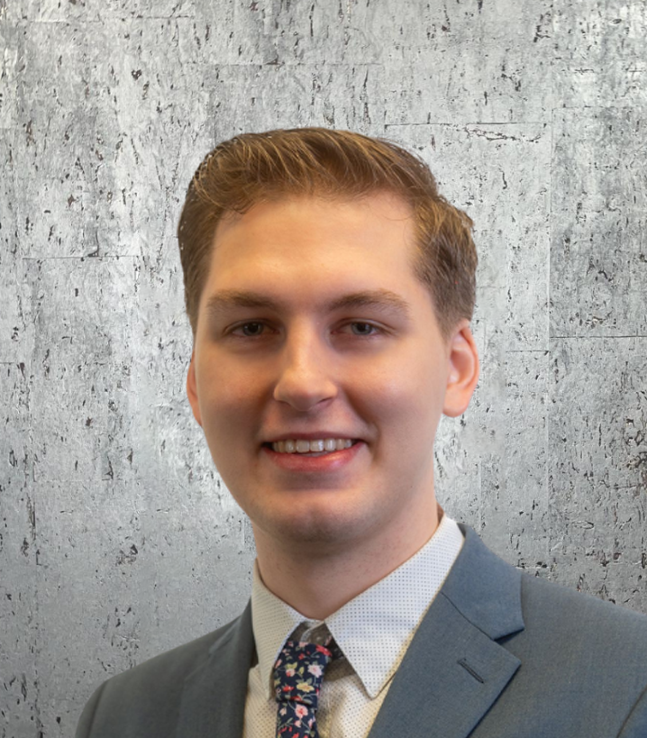 A man in a suit and tie is smiling for the camera