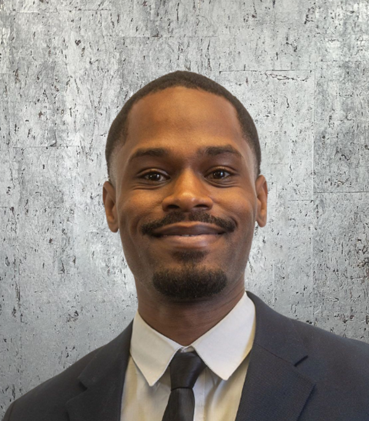 A man in a suit and tie is smiling for the camera