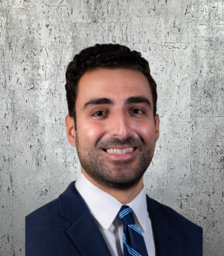 A man in a suit and tie is smiling for the camera
