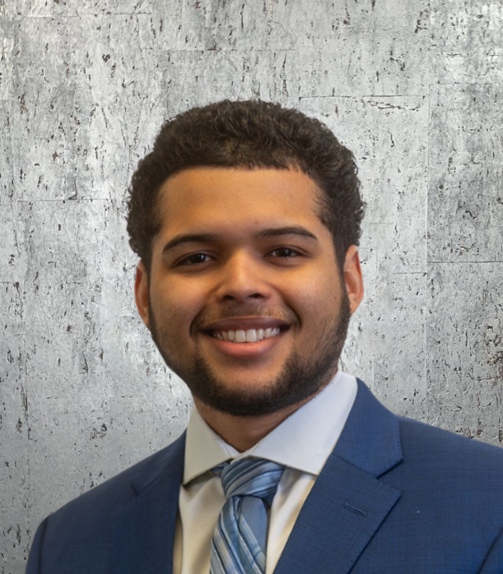 A man in a suit and tie is smiling for the camera