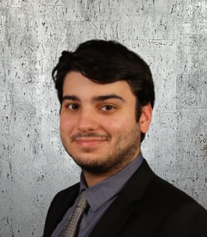 A man in a suit and tie is smiling for the camera