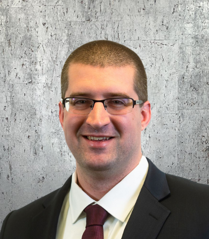 A man in a suit and tie is smiling for the camera
