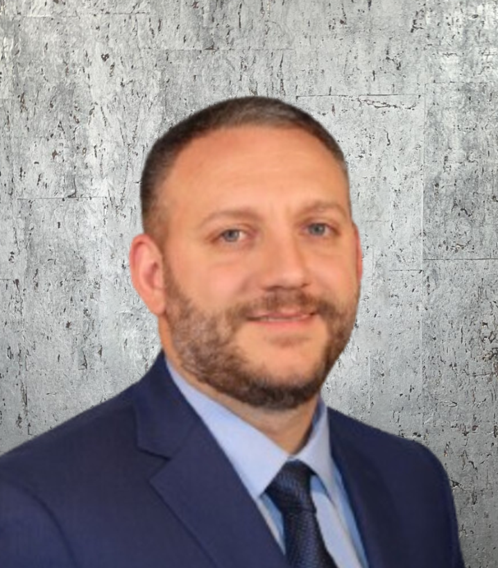 A man with a beard is wearing a suit and tie.