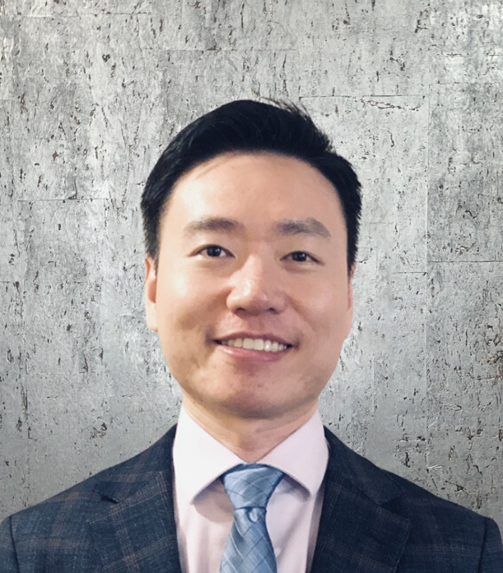 A man in a suit and tie is smiling for the camera