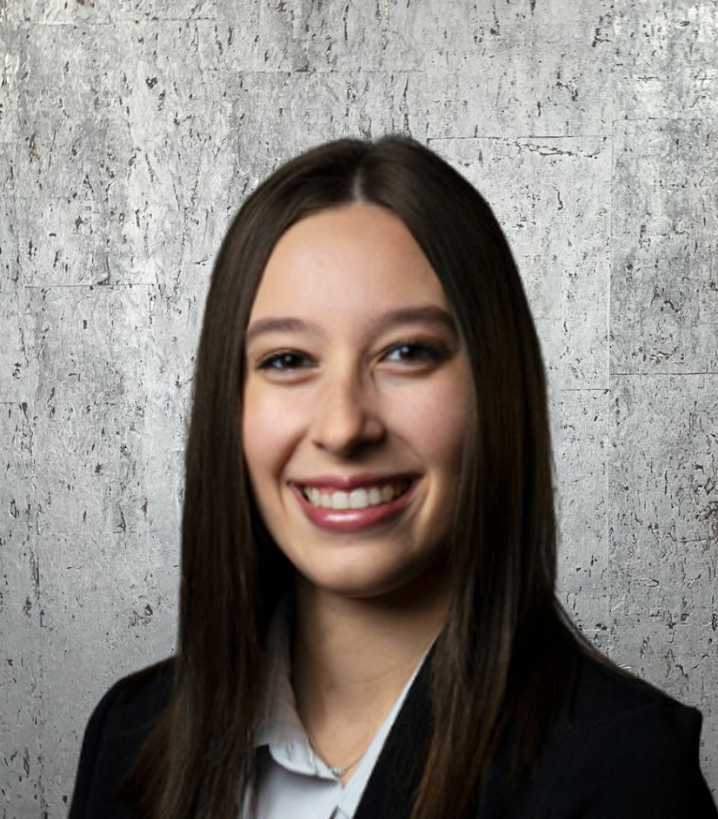 A woman wearing a black jacket and white shirt smiles for the camera
