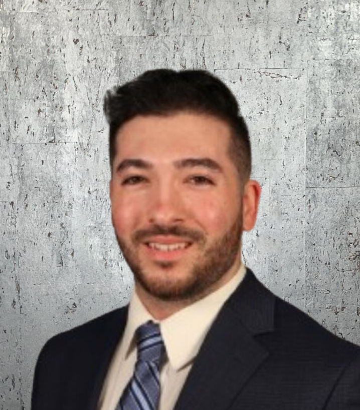 A man in a suit and tie is smiling for the camera