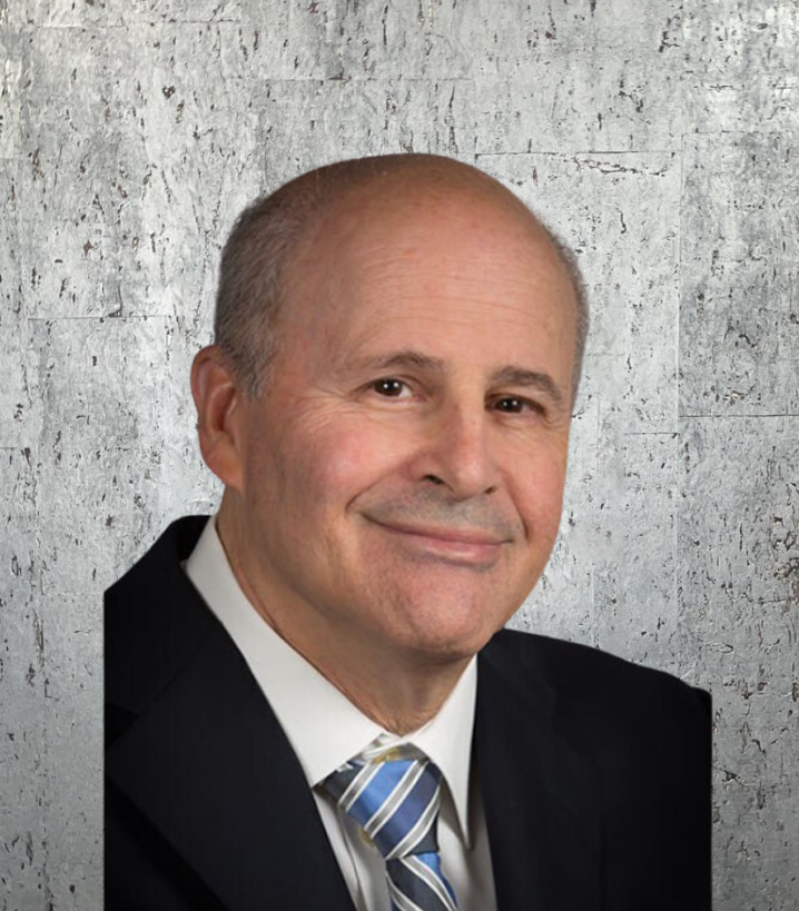 A man in a suit and tie is smiling for the camera