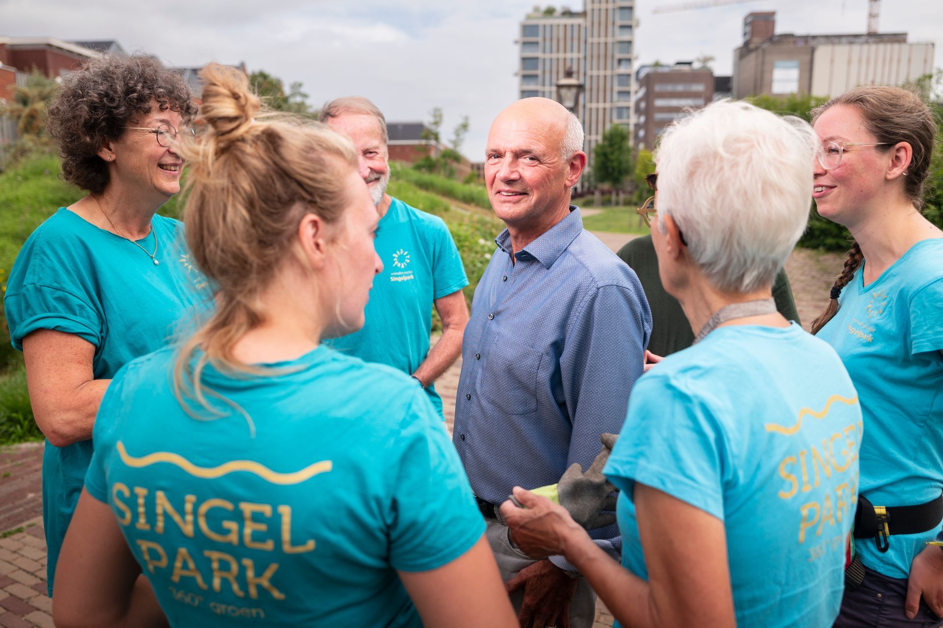 Een groep mensen in turquoise shirts met het 