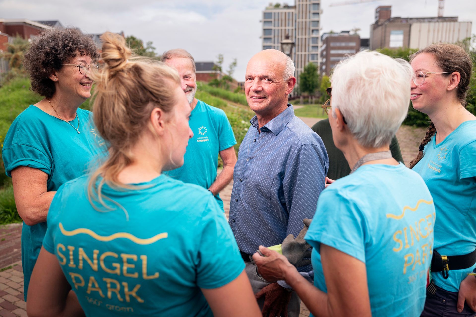 Een groep mensen in turquoise shirts met het 