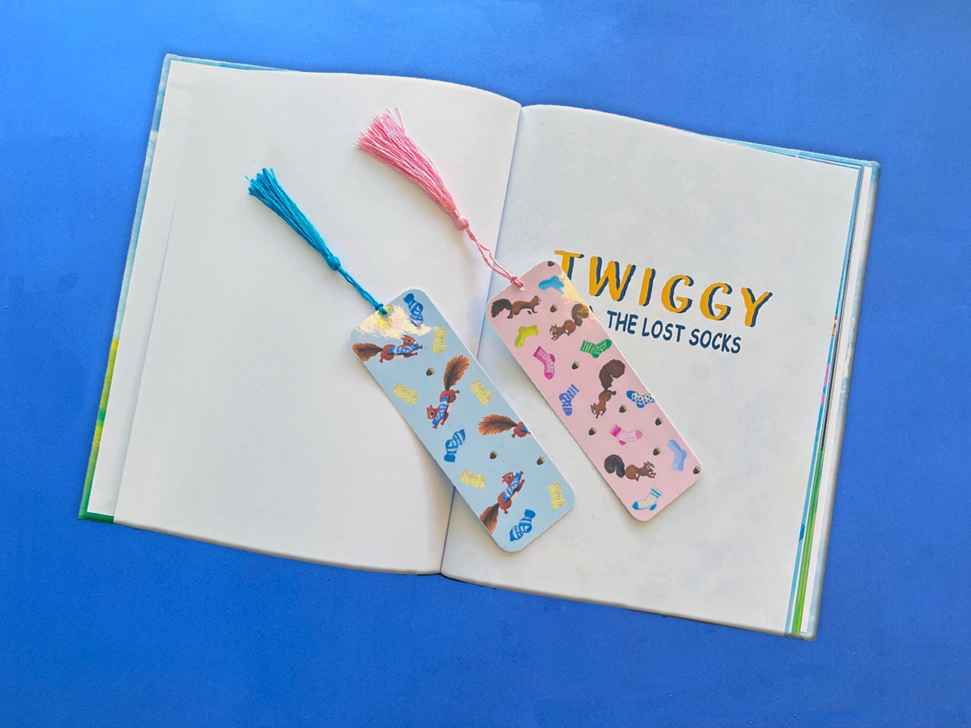 Two colorful handmade bookmarks resting on an open book titled 