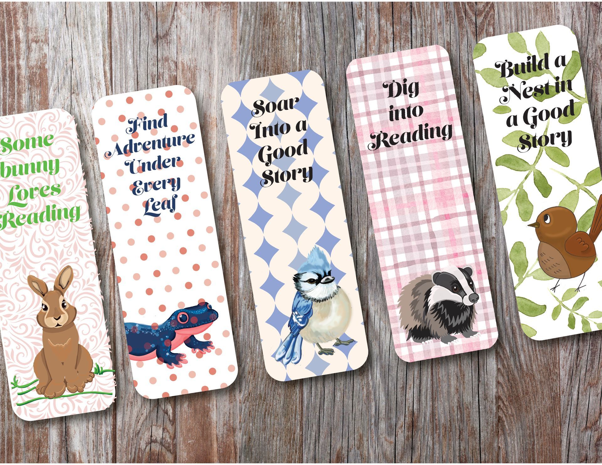 Five animal-themed bookmarks with inspirational reading quotes on a wooden background.
