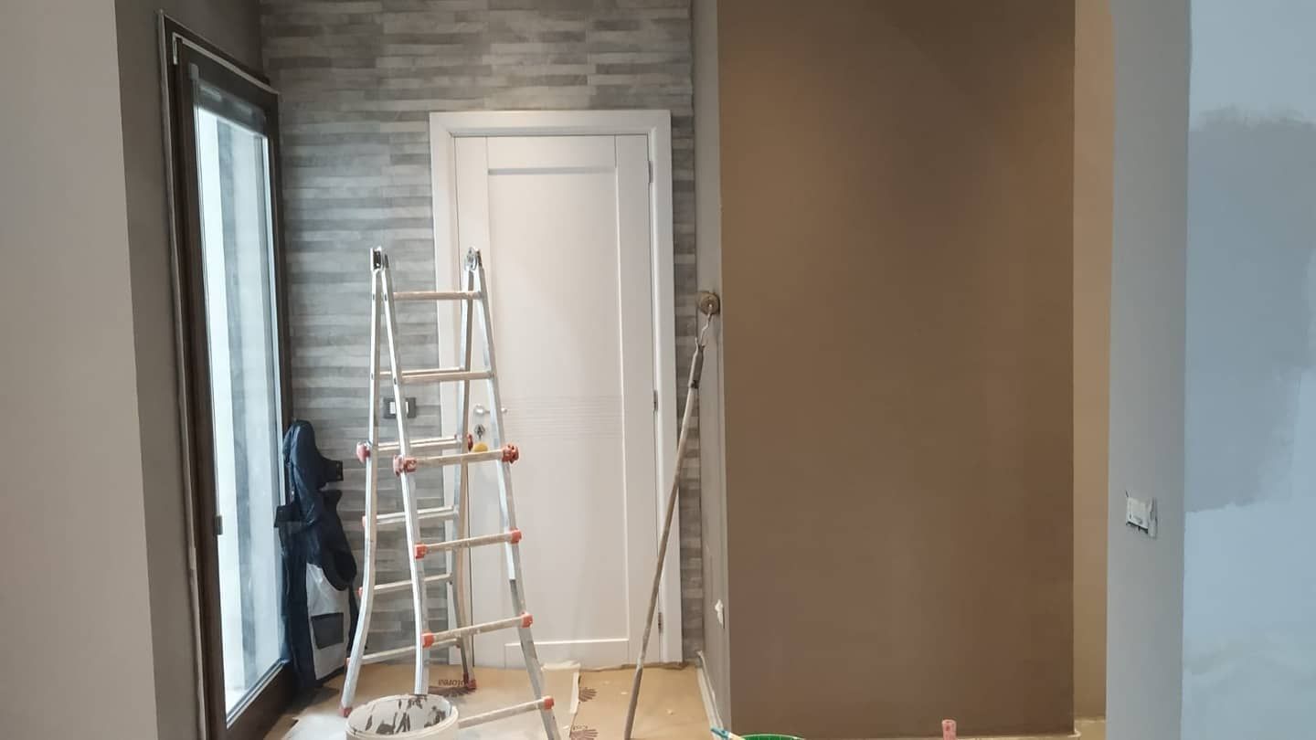 Una scala è appoggiata in una stanza accanto a una porta.