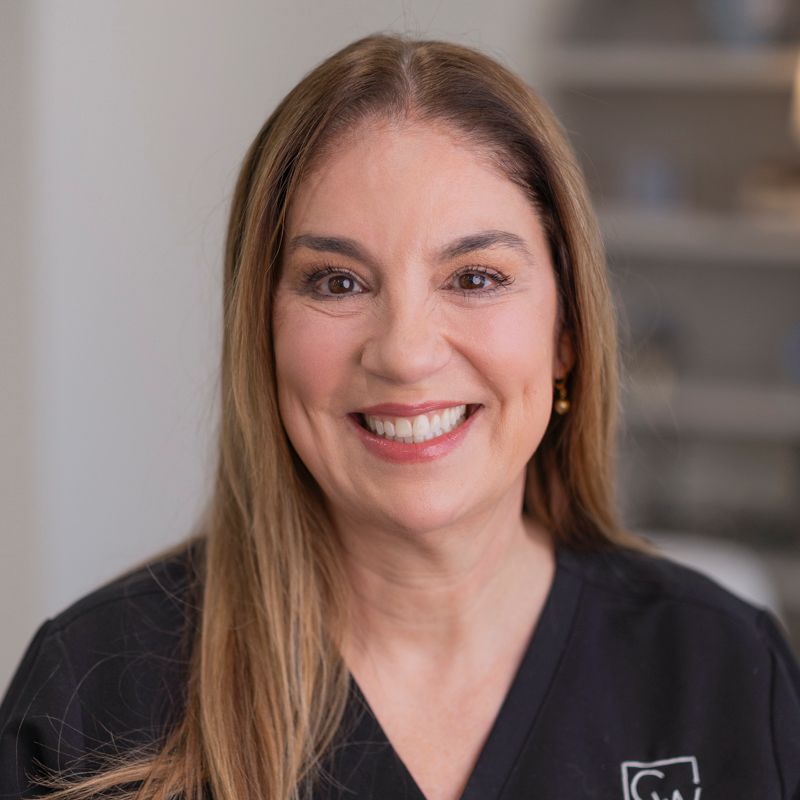 Image of four CWFPS staff members smiling at the camera at the Facial Plastic Surgery office in Leawood, KS.