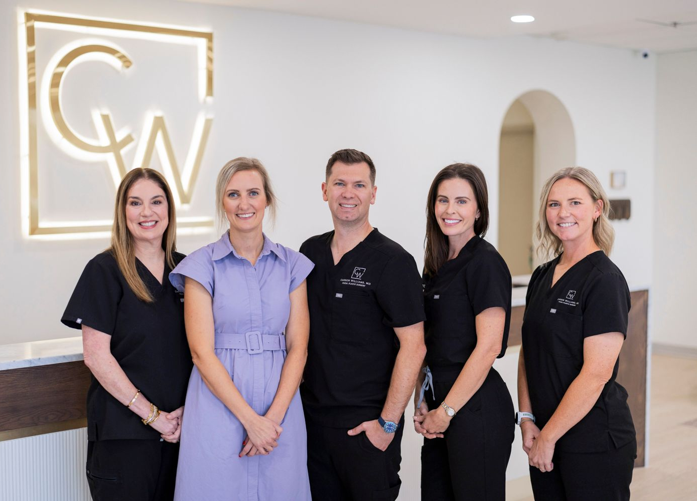 Image of four CWFPS staff members smiling at the camera at the Facial Plastic Surgery office in Leawood, KS.