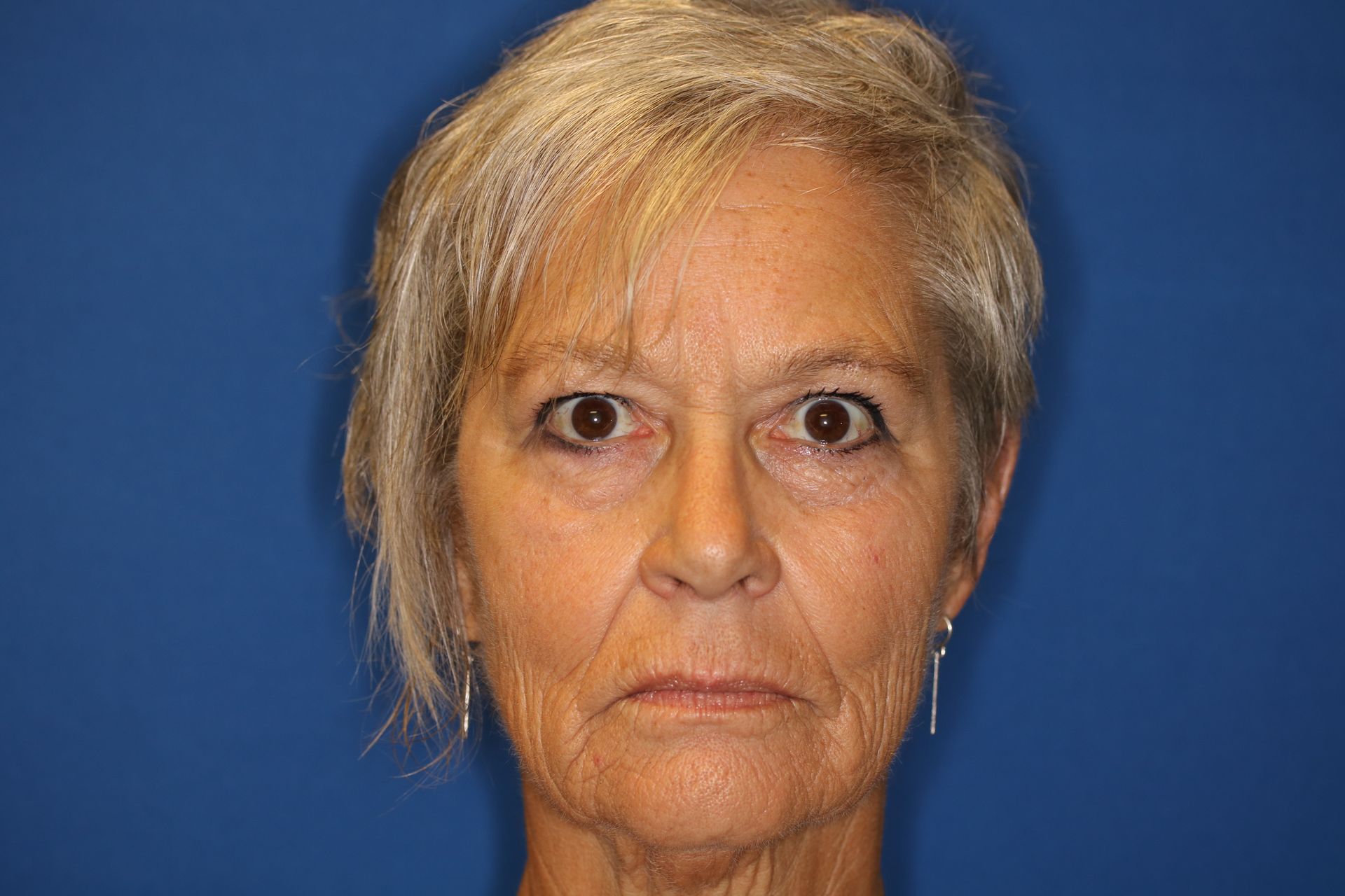 A close up of a woman 's face with a blue background.