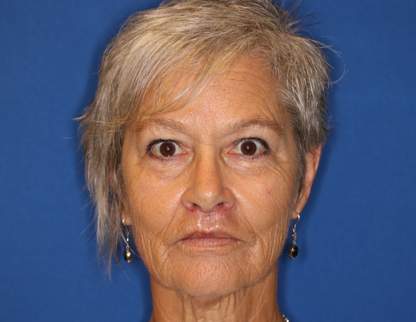 A close up of a woman 's face with a blue background.