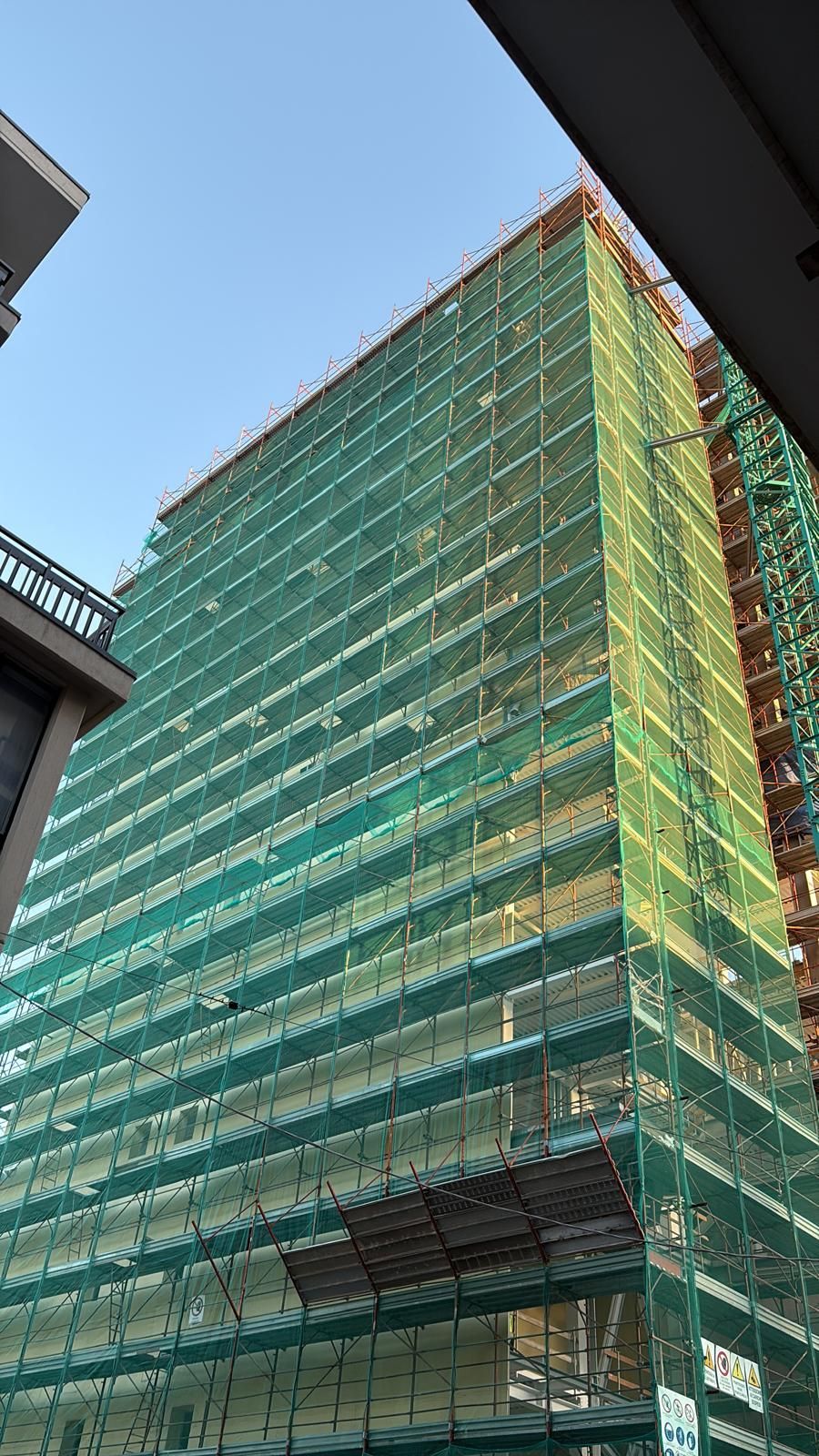 Operai edili sulle impalcature al tramonto.