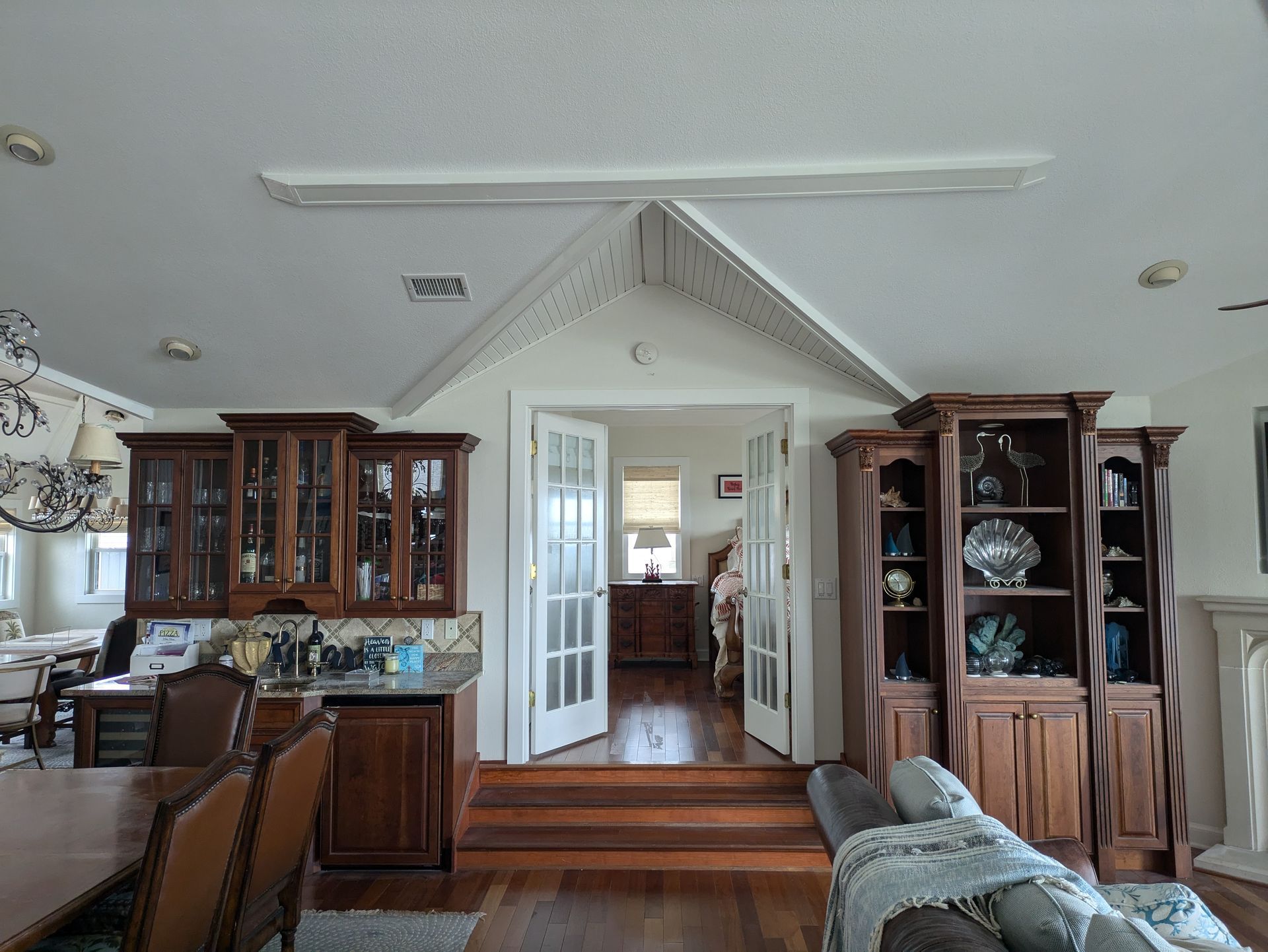 Interior view of a living room with wooden cabinets, a doorway, and a raised ceiling.