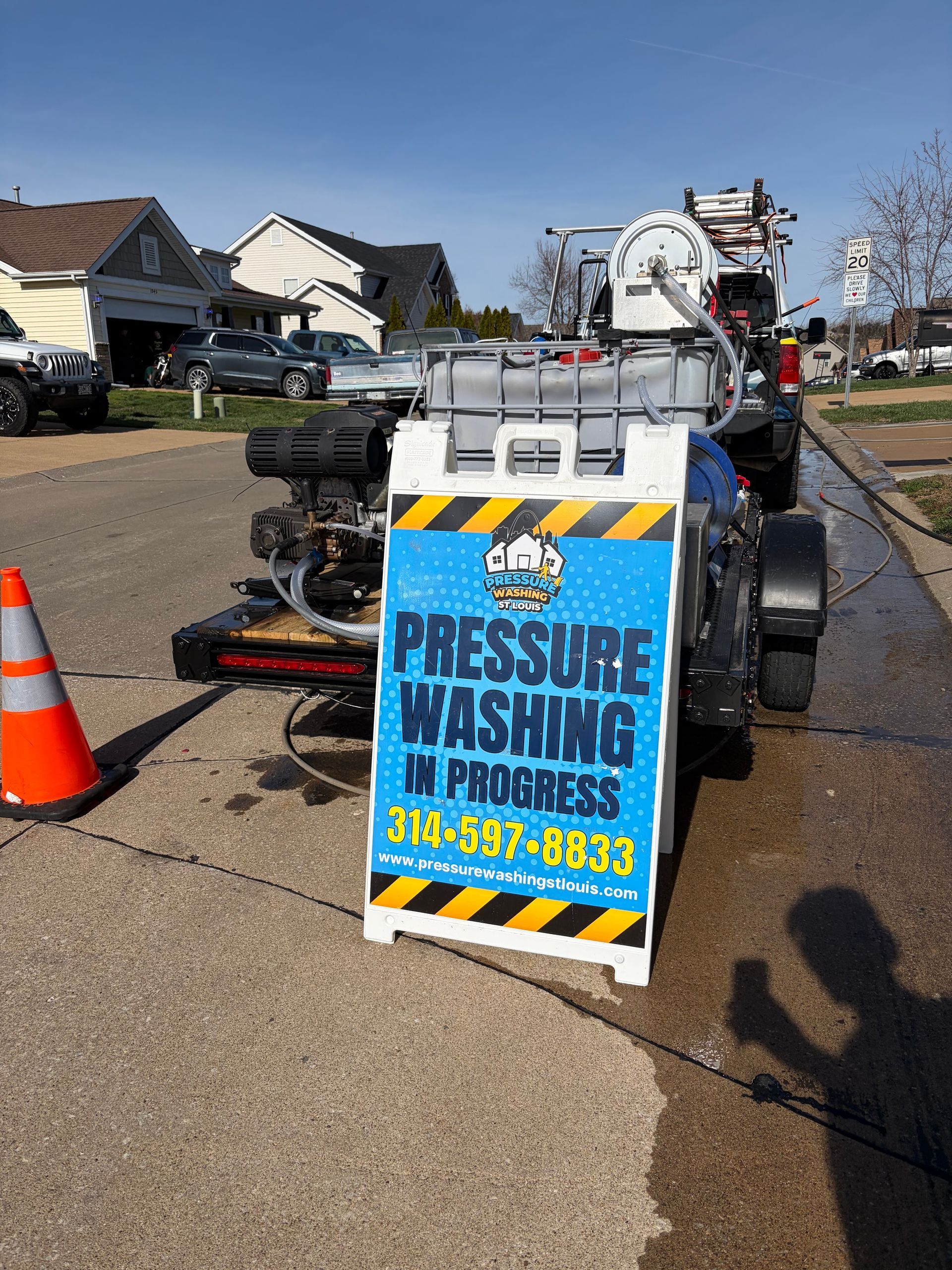 A pressure washing setup on a trailer with a blue sign that reads 